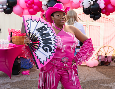 Austin Walker in Pink Outfit and Cowboy hat, with Bang fan